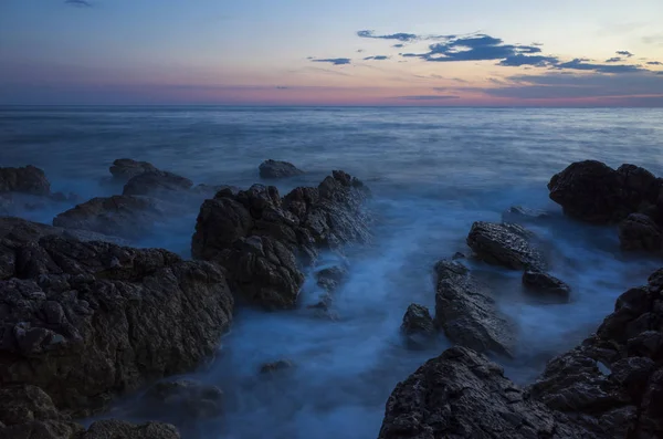 Güzel manzara ve doğa fotoğraf gün batımı Hırvatistan Avrupa'nın Adriyatik denizde. Güzel renkli açık havada resim. Okyanus, kayalar ve akşam gökyüzüne sakin, huzurlu resmi.
