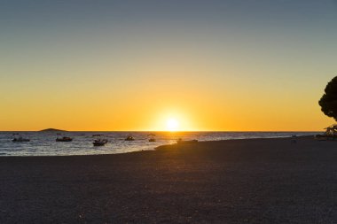 günbatımı sırasında denizde yüzen tekne siluetleri 