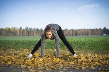 Genç kadın açık havada egzersiz yaparak spor giyim 
