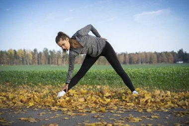 Genç kadın açık havada egzersiz yaparak spor giyim 