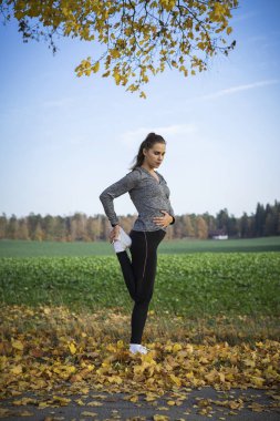 Genç kadın açık havada egzersiz yaparak spor giyim 