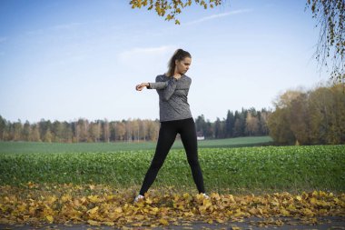 Genç kadın açık havada egzersiz yaparak spor giyim 