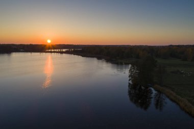 göl günbatımı arka plan üzerinde orman tarafından yuvarlak görünümünü