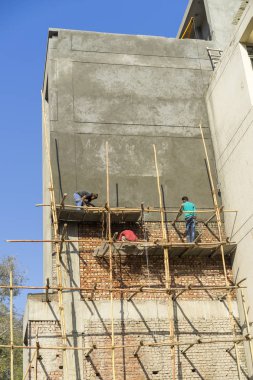 İnşaat işçileri bina manzaralı ve mavi gökyüzü