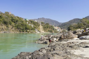 nehir kenarı görünümü ve nehir akan yalak Hint şehir insanlar gündüz sahilde oturan  
