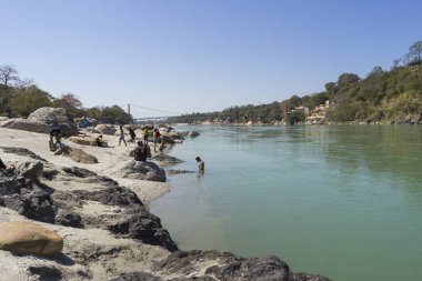 nehir kenarı görünümü ve nehir akan yalak Hint şehir insanlar gündüz sahilde oturan  