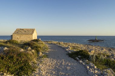 mavi gökyüzü arka plan üzerinde kayalar üzerinde taşlı evin görünümü 