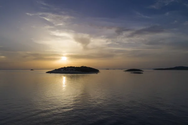 dramatic sunset over islands in ocean