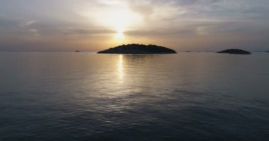 gün batımı arka planda sakin deniz ile çevrili adalar görünümü