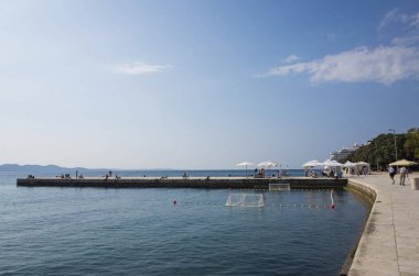 people walking on the stone seaside, sea view