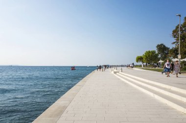 people walking on the stone seaside, sea view