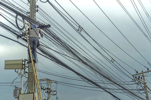 Trabajador de electricidad vietnamita subir alto en poste eléctrico para representar — Foto de Stock