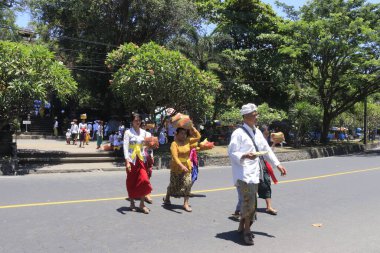 Endonezya 'da. Ubud, insanlar Canang sari adağı sırasında Lempuyang Tapınağı yakınlarında yürüyorlar.