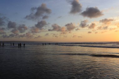 Endonezya 'da deniz ve plajın üzerinde güneş ve akşam gökyüzü batıyor