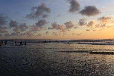 Endonezya 'da deniz ve plajın üzerinde güneş ve akşam gökyüzü batıyor