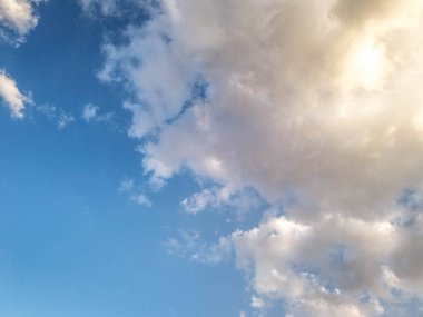 Güneş mavi gökyüzünde bulutları aydınlattı, doğal duvar kağıdı