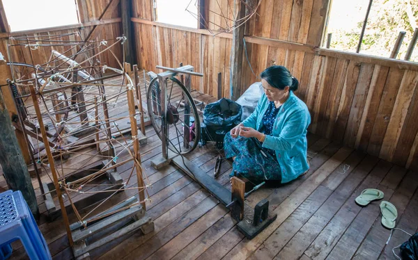 İnsanlar atölyede el dokuma tezgahıyla çalışıyorlar..