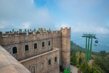 Sunworld Ba Na Hills Parkı 'nda yeşil ve mavi bulutlu gökyüzü olan kayalık binalar.
