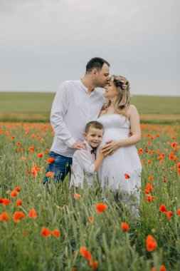 Kırmızı bir haşhaş alanında genç Aile