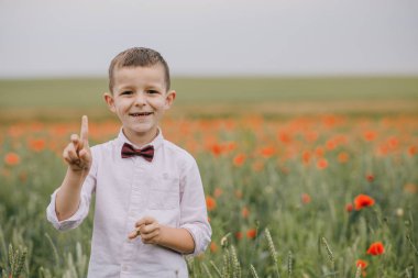 Haşhaş alanında ayakta mutlu küçük çocuk