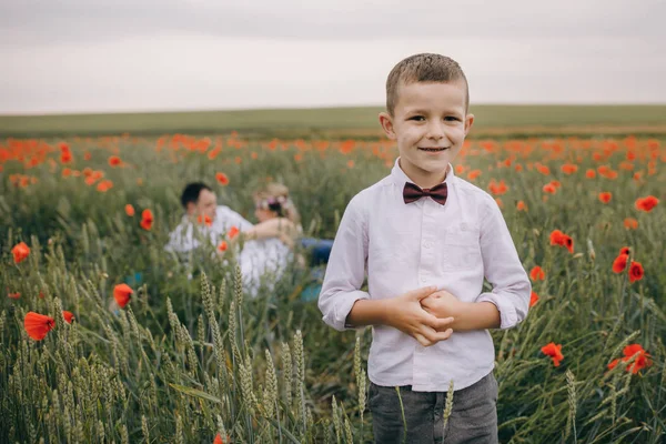 Šťastná rodina, spočívající na makové pole — Stock fotografie