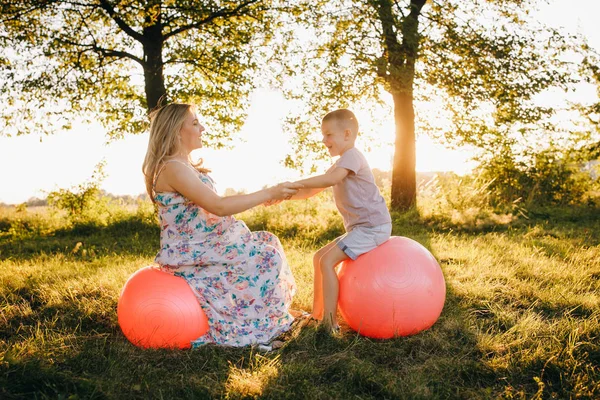 Mladá rodina Matka a její syn hraje na fitness míče v letním parku — Stock fotografie