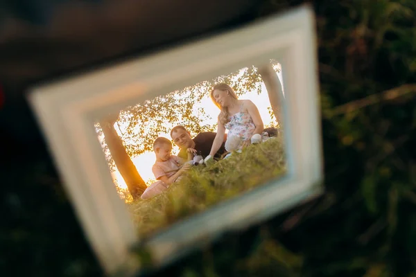 Rám s rodinné fotografie na trávě — Stock fotografie