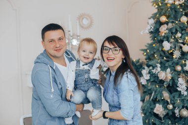 Güzel anne küçük şirin oğulları kollarında tutun. Noel aile fotoğrafı