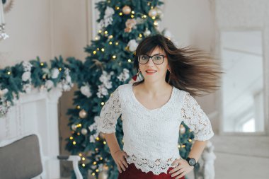 Beyaz kazak ve gözlük gülümsüyor Noel dekorasyonu genç kız