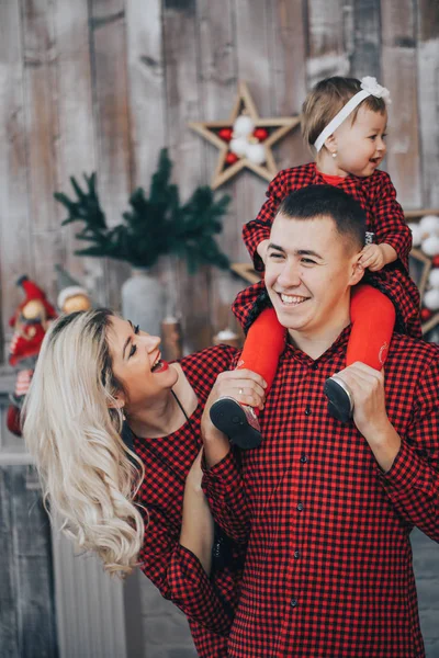 Šťastná rodina s jeho malá dcerka společně v místnosti zařízené svátky s vánoční stromek a věnec na pozadí — Stock fotografie