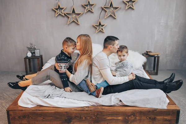 Rodina ležící na posteli v ložnici — Stock fotografie