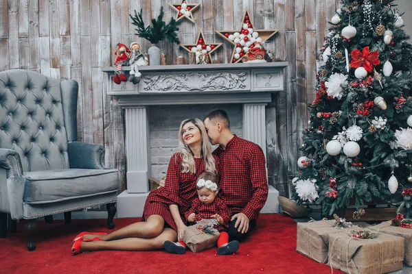 Šťastná rodina s jeho malá dcerka společně v místnosti zařízené svátky s vánoční stromek a věnec na pozadí — Stock fotografie