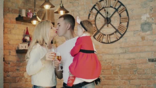 Família com uma pequena filha em um terno santas no fundo das luzes de Natal — Vídeo de Stock
