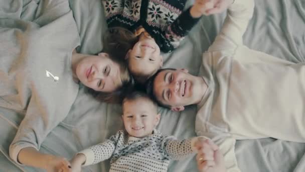 Retrato de uma família caucasiana com dois filhos, feliz e sorridente na cama — Vídeo de Stock