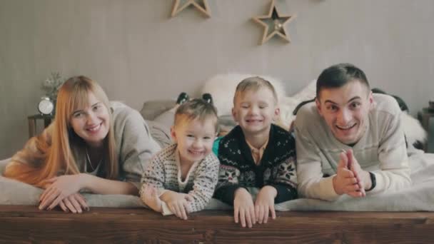 Καυκάσιος οικογένεια με δύο παιδιά, ευτυχισμένη και χαμογελαστή στο κρεβάτι — Αρχείο Βίντεο