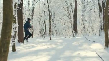 Adam kışın bir orman yolu üzerinde çalışır.