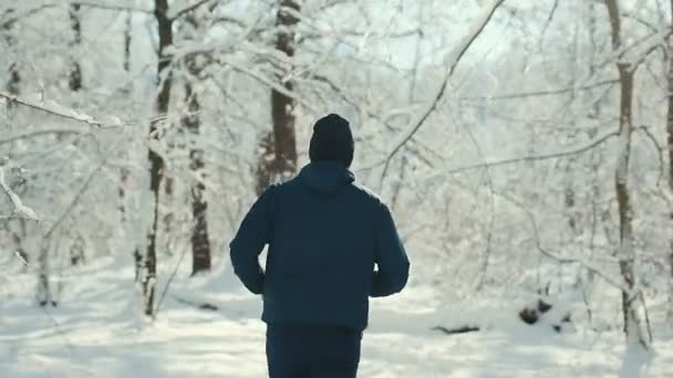 Jonge sporter loopt door besneeuwde Forrest — Stockvideo