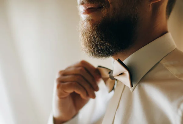 Homem corrige a borboleta closeup homens peito vestindo camisa branca, ajustando bowtie usando as mãos, rosto parcialmente visível, homens se vestindo conceito — Fotografia de Stock