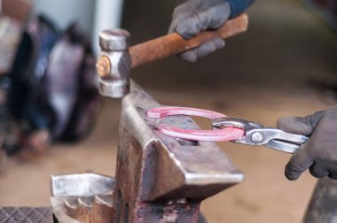 Atların toynakları kadar onları koymadan önce yanan at ayakkabı şekillendirme demirci.