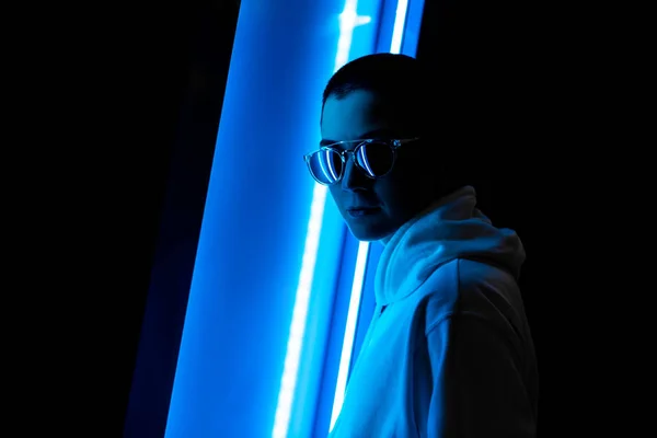 Kısa saçlı bir kadın bir neon ışık düşük anahtar portresi