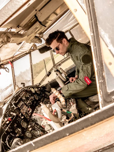 Красивый молодой пилот сидит в кабине пилота — стоковое фото