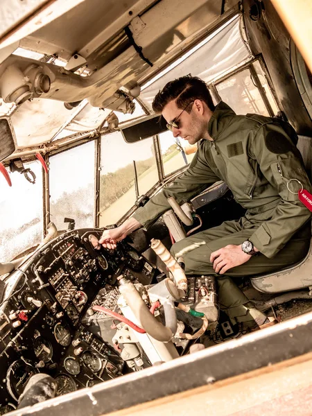Красивый молодой пилот сидит в кабине пилота — стоковое фото