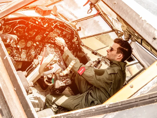 Un piloto joven y guapo sentado en la cabina — Foto de Stock