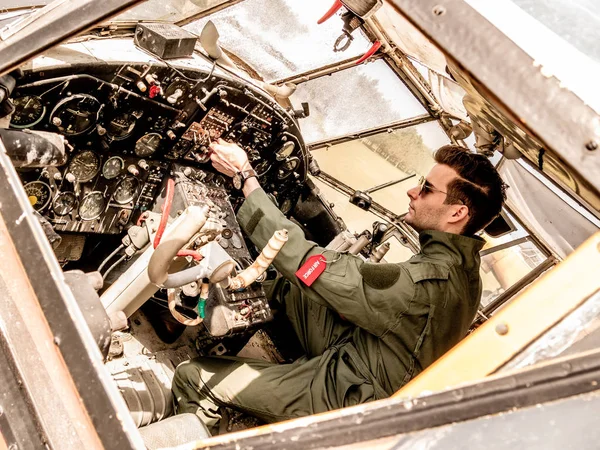 Un piloto joven y guapo sentado en la cabina — Foto de Stock