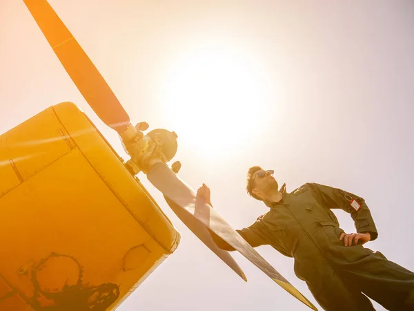 En stilig ung pilot som står bredvid propellern — Stockfoto