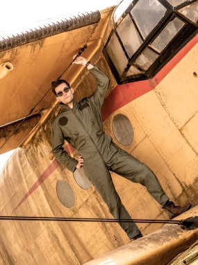 Bir uçağın kanadında duran yakışıklı genç bir pilot