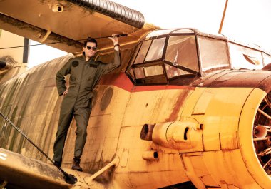 Bir uçağın kanadında duran yakışıklı genç bir pilot