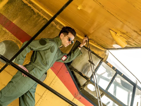 Um belo jovem piloto de pé na asa de um avião — Fotografia de Stock