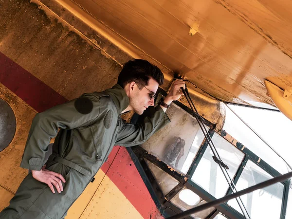 Um belo jovem piloto de pé na asa de um avião — Fotografia de Stock