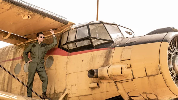 Bir uçağın kanadında duran yakışıklı genç bir pilot